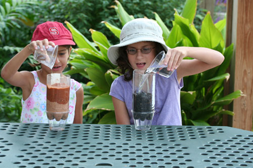 two girls performing a soil experiment